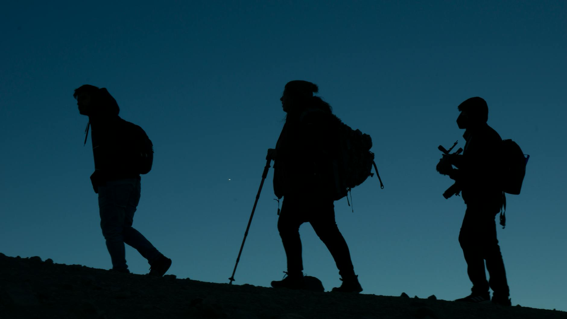 silhouettes of group of people on mountain during sunset